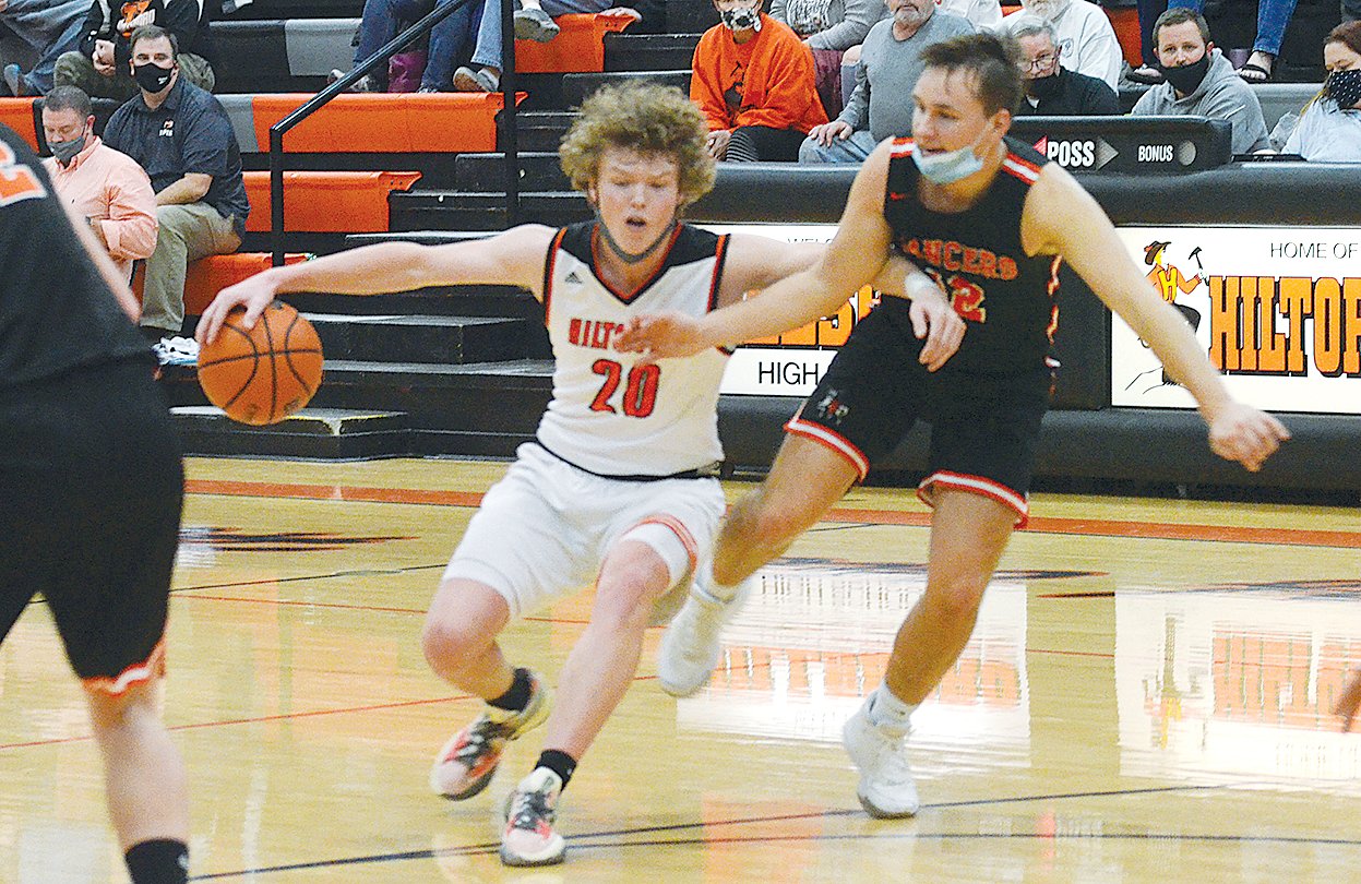 Hillsboro’s Drake Vogel (#20) tries to drive past Will Jenkins of Lincolnwood during the county rivalry match-up on Tuesday, Dec. 7. Vogel would have 20 points in the game to help the Toppers to a 69-53 win over the Lancers.